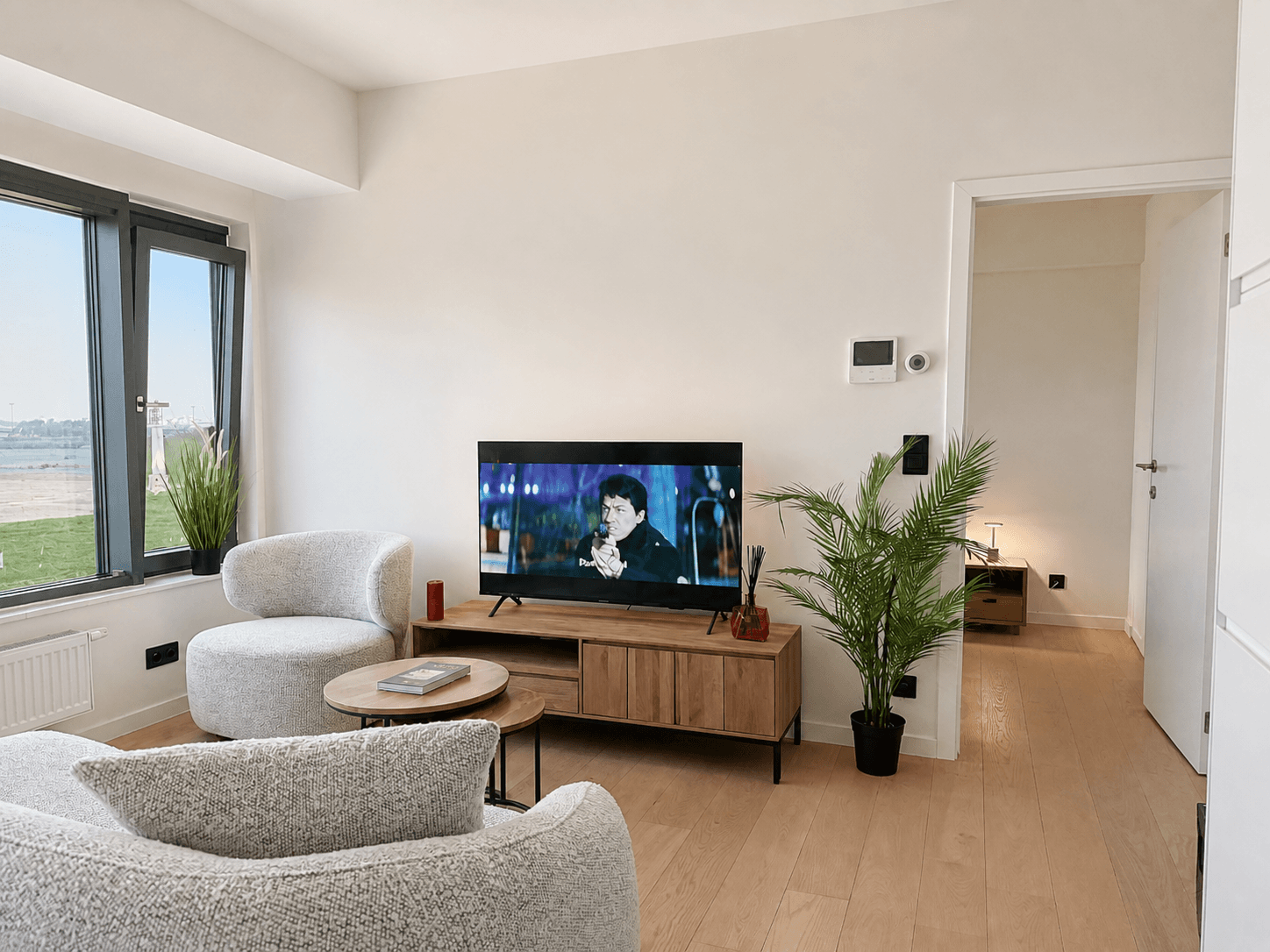 Woonkamer vanuit de eethoek met zicht op de televisie